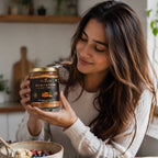 Woman holding jar of berryessence sea buckthorn berry spread in a kitchen setting.