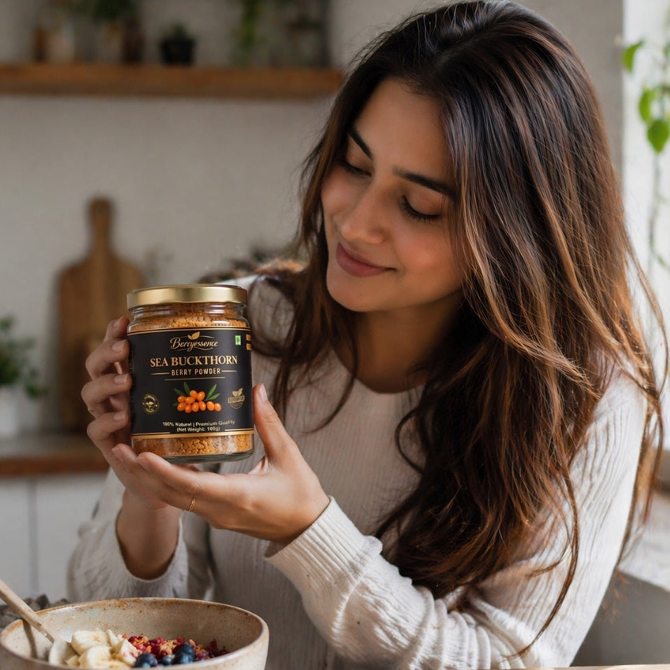 Woman holding jar of berryessence sea buckthorn berry spread in a kitchen setting.